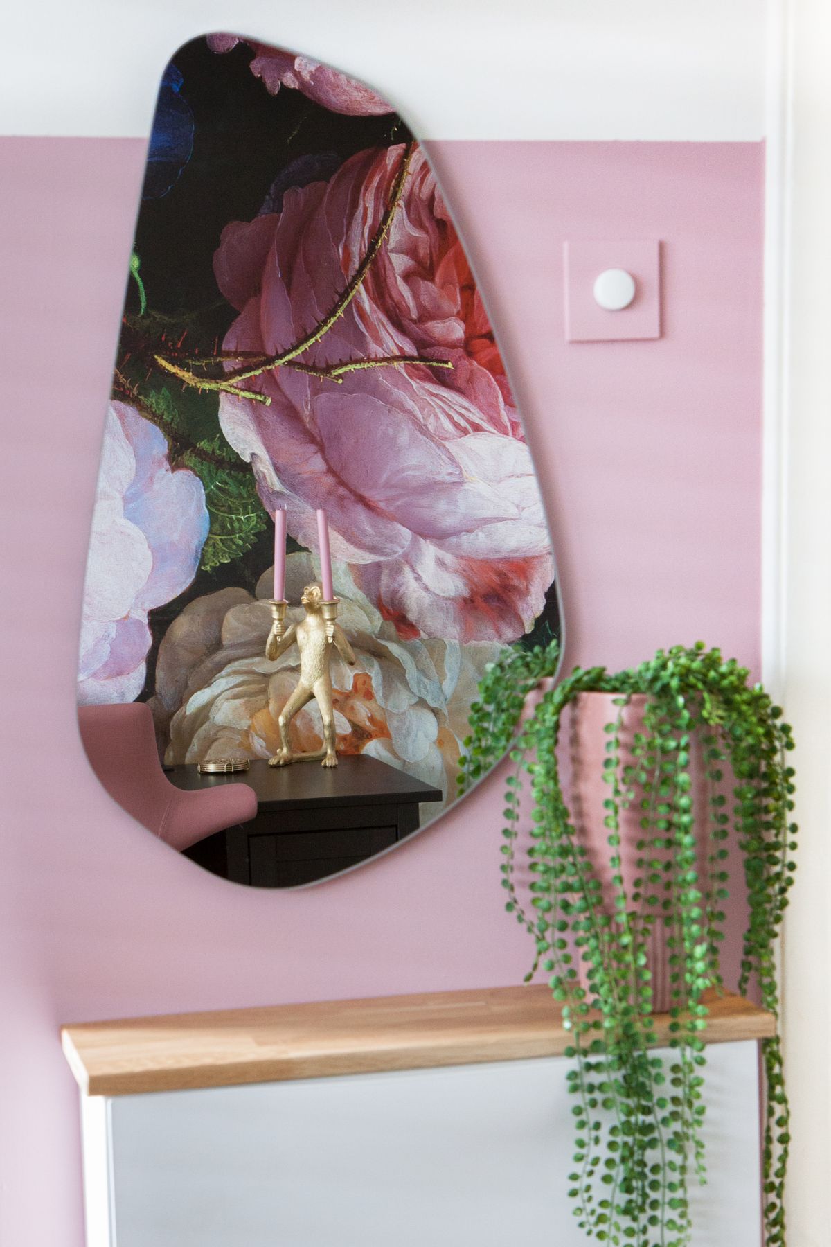 Roze muur met organische spiegel en bloempot